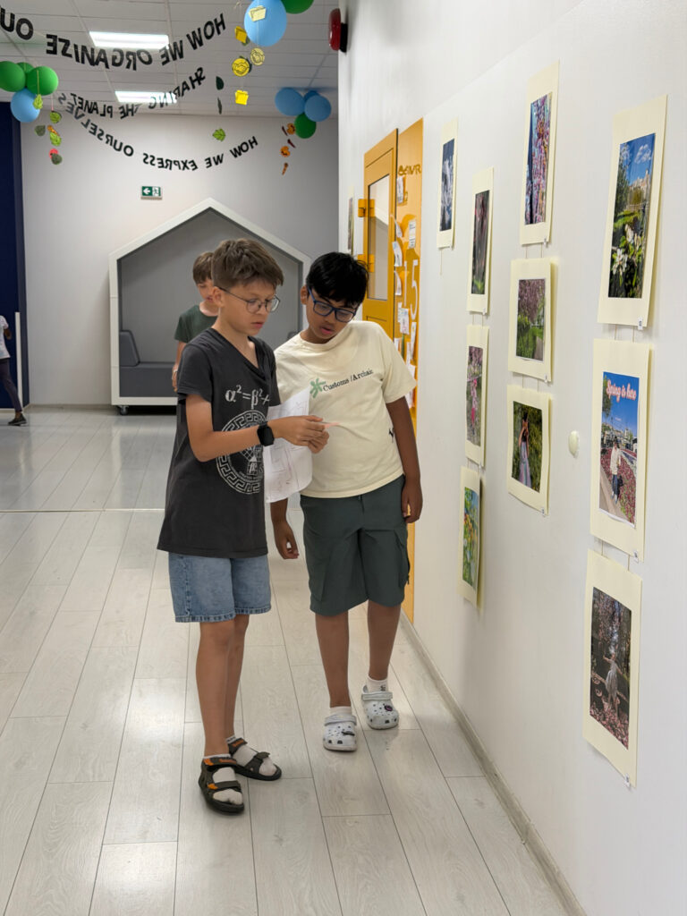 Dwóch uczniów Da Vinci's Primary School przegląda mapę na korytarzu szkolnym podczas aktywności Summer Camp.