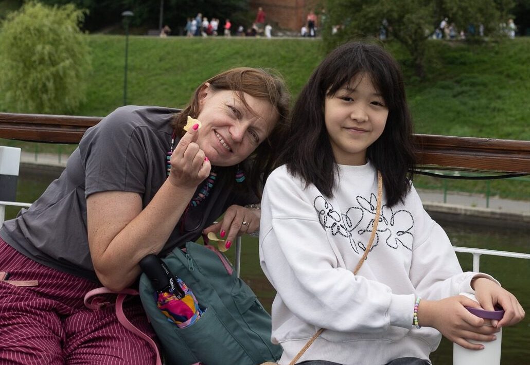 Nauczycielka i uczennica na pokładzie statku na Wiśle z Wawelem w tle podczas wycieczki w ramach Summer Camp Da Vinci's Primary School w Krakowie.